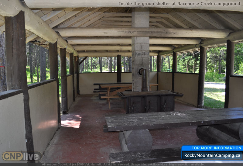 A wood stove and tables inside the group shelter at Racehorse Creek Campground